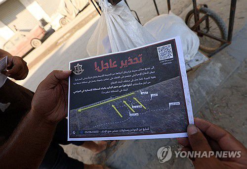 이스라엘군의 대피 경고전단을 읽고 있는 팔레스타인 주민 [로이터 연합뉴스 자료사진]