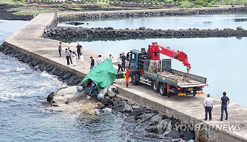 제주 해안서 발견된 정체불명의 보트(서귀포=연합뉴스) 박지호 기자 = 해경과 경찰 등 관계자들이 8일 오전 제주시 한경면 용수리 해안가에서 이날 오전 발견된 미확인 보트를 조사해 인양하려 하고 있다.     해경은 밀입국, 해양사고 등의 가능성을 열어 놓고 조사하고 있다고 밝혔다. 2025.9.8 jihopark@yna.co.kr