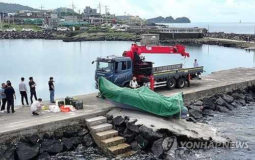 제주 해안서 발견된 정체불명의 보트(서귀포=연합뉴스) 박지호 기자 = 해경과 경찰 등 관계자들이 8일 오전 제주시 한경면 용수리 해안가에서 이날 오전 발견된 미확인 보트를 조사해 인양하려 하고 있다.     해경은 밀입국, 해양사고 등의 가능성을 열어 놓고 조사하고 있다고 밝혔다. 2025.9.8 jihopark@yna.co.kr