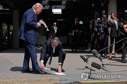트럼프 대통령이 떨어뜨린 서류 줍는 스타머 총리[AFP 연합뉴스 자료사진. 재판매 및 DB 금지]