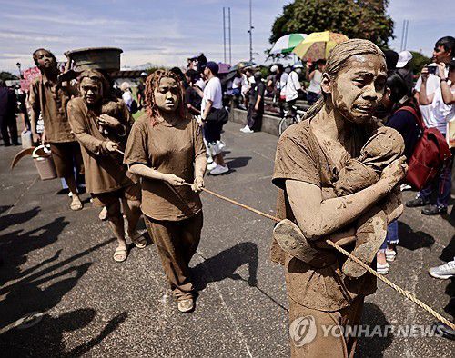 진흙을 뒤집어쓴 채 퍼포먼스를 하는 시위자들[EPA 연합뉴스. 재판매 및 DB 금지]