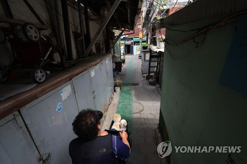 산책길(서울=연합뉴스) 박동주 기자 = 혼자 살다 쓸쓸히 생을 마무리하는 '고독사'를 2027년까지 20% 줄이는 것을 목표로 정부가 고독사 위험군 발굴과 지원을 강화하기로 했다.     사진은 이날 서울 영등포구 쪽방촌에서 두 마리의 강아지와 지내는 한 어르신이 산책하는 모습. 2023.5.18 pdj6635@yna.co.kr