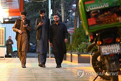인터넷이 복원된 1일 휴대전화 보는 아프간 카불 시민들[AFP 연합뉴스 자료사진. 재판매 및 DB 금지]