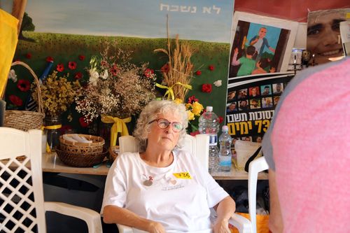 나할오즈 키부츠 피해자 기리는 천막의 나오미(텔아비브=연합뉴스) 김동호 특파원 = 11일(현지시간) 이스라엘 텔아비브미술관 앞 '인질 광장'의 나할오즈 키부츠 피해자 추모 천막에서 자원봉사자 나오미씨가 방문객들과 대화하고 있다. 2025.10.12 dk@yna.co.kr