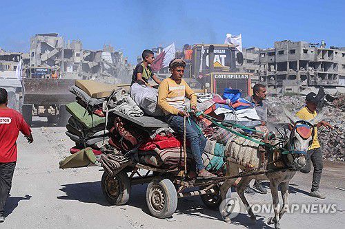14일(현지시간) 가자시티 거리를 지나는 피란민들 모습[AFP 연합뉴스]