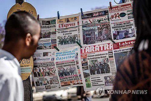 군정 수립 소식을 전하는 마다가스카르 신문을 읽는 현지 주민[AFP=연합뉴스]