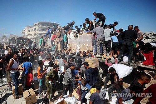 구호 트럭에서 구호품 상자를 수령하는 팔레스타인 주민들[AFP=연합뉴스. 재판매 및 DB 금지]
