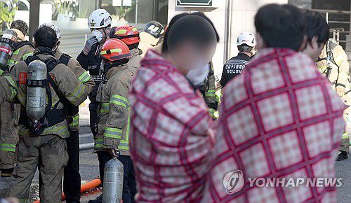 창원 오피스텔 화재…주민 대피(창원=연합뉴스) 김동민 기자 = 29일 오전 경남 창원시 마산합포구 한 오피스텔에서 화재가 발생, 거주자 등이 오피스텔에서 떨어진 곳에서 담요를 덮고 추위를 녹이고 있다. 2025.10.29 image@yna.co.kr