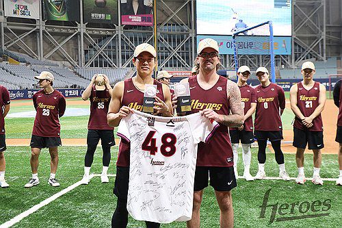 웰스에게 사인이 담긴 유니폼 선물하는 키움 주장 송성문(서울=연합뉴스) 웰스(앞줄 오른쪽)가 23일 서울 구로구 고척스카이돔에서 키움 주장 송성문으로부터 선수단의 친필 사인이 담긴 유니폼을 받고 있다. 이날 키움은 웰스 송별 행사를 했다. 2025.7.23 [키움 히어로즈 제공. 재판매 및 DB 금지] photo@yna.co.kr