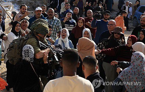 요르단강 서안 긴장(툴카렘 AP=연합뉴스) 지난 18일(현지시간) 요르단강 서안의 툴카렘 부근에서 난민촌 복귀를 요구하는 이스라엘 군인들을 팔레스타인 주민들이 둘러싸고 항의 중이다. 2025.11.19 photo@yna.co.kr