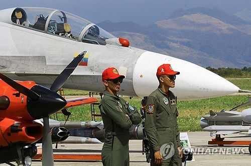 베네수엘라 항공산업 박람회(마라카이 <베네수엘라> 로이터=연합뉴스) 2025년 11월 29일 베네수엘라 마라카이에서 열린 베네수엘라 항공산업 박람회에서 군인들이 군용기 옆에 서 있다. (REUTERS/Juan Carlos Hernandez) 2025.11.30.