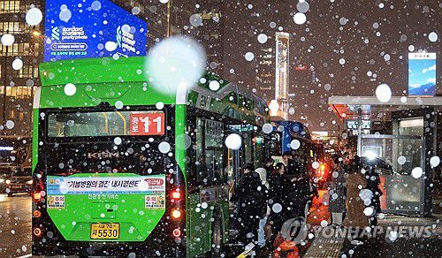 눈 내리는 퇴근길(서울=연합뉴스) 최재구 기자 = 서울 지역에 올해 첫눈이 내린 4일 서울 광화문에서 시민들이 버스에 탑승하고 있다. 2025.12.4 jjaeck9@yna.co.kr