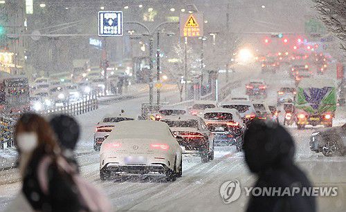 수도권·강원 등 대설 특보 발표(서울=연합뉴스) 이진욱 기자 =  서울·인천·경기·강원 등 4개 시도에 대설특보가 발효된 4일 서울 마포구 홍대 인근에서 제설작업이 완료되지 못한 곳을 지나는 차량이 힘겹게 언덕길을 오르고 있다. 2025.12.4 cityboy@yna.co.kr