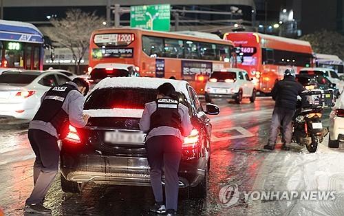 차 미는 경찰(서울=연합뉴스) 이진욱 기자 =  서울·인천·경기·강원 등 4개 시도에 대설특보가 발효된 4일 서울 마포구 홍대 인근 제설작업이 완료되지 못한 도로에서 경찰들이 언덕길 차를 밀고 있다. 2025.12.4 cityboy@yna.co.kr