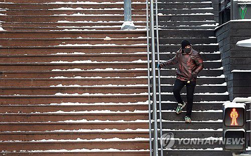 빙판길에 난간 붙잡고 이동(서울=연합뉴스) 한종찬 기자 =  폭설 후 한파로 도로 곳곳이 얼어붙은 5일 서울 이태원역 인근에서 시민이 빙판길을 조심히 걷고 있다. 2025.12.5 saba@yna.co.kr
