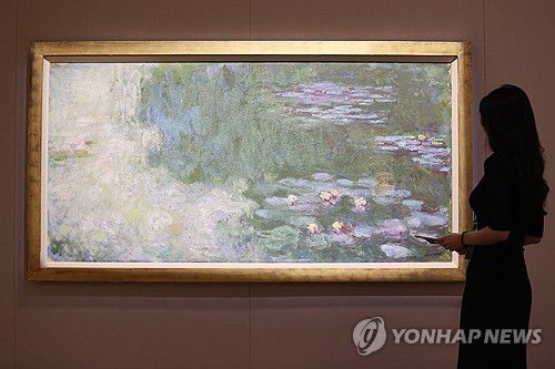 모네의 '수련이 있는 연못'국립현대미술관 과천에서 열린 MMCA 해외 명작 '수련과 샹들리에' 언론공개회에 참석자가 클로드 모네의 '수련이 있는 연못'을 둘러보고 있다.  [연합뉴스 자료사진]