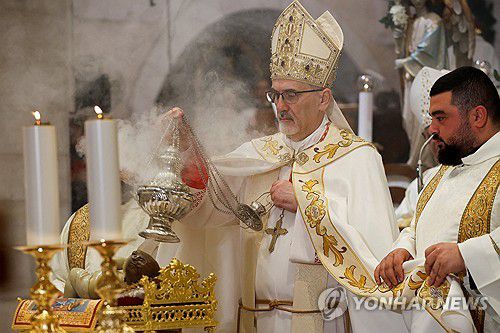 (로이터=연합뉴스) 25일 서안지구 베들레헴의 예수 탄생 교회에서 가톨릭 교회 예루살렘 라틴 총대주교인 피에르바티스타 피차발라 추기경이 자정 미사를 집전하고 있다.