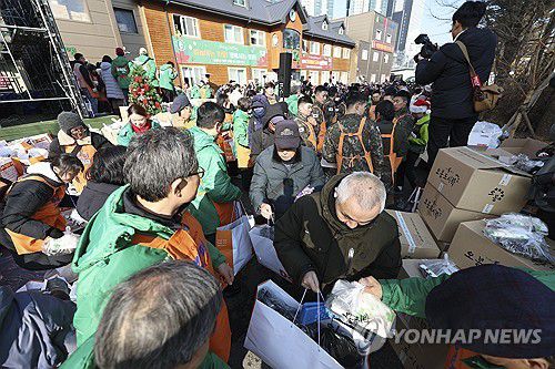 밥퍼나눔운동본부에서 열린 거리 성탄 예배(서울=연합뉴스) 김성민 기자 = 크리스마스를 하루 앞둔 24일 서울 동대문구 밥퍼나눔운동본부에서 열린 거리 성탄 예배에서 자원봉사자들이 참가자들에게 음식과 생필품 등을 전달하고 있다. 2025.12.24 [공동취재] ksm7976@yna.co.kr