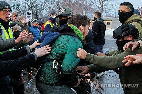 8일 미네소타 미니애폴리스 연방청사 앞에서 연방 요원들에게 끌려가는 시위대[로이터=연합뉴스. 재판매 및 DB 금지]