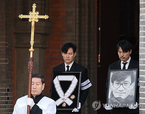 고 안성기 영정과 훈장 든 이정재와 정우성(서울=연합뉴스) 이재희 기자 = 9일 서울 중구 명동성당에서 열린 배우 안성기의 장례 미사가 끝난 뒤 영결식을 위해 고인의 영정과 금관문화훈장을 든 배우 정우성, 이정재가 영결식장으로 향하고 있다. 2026.1.9 scape@yna.co.kr