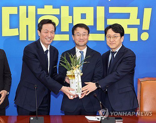대통령 축하 난 받는 한병도 민주당 신임 원내대표(서울=연합뉴스) 배재만 기자 = 더불어민주당 한병도 신임 원내대표(가운데)가 12일 국회에서 우상호 청와대 정무수석을 만나 이재명 대통령의 축하 난을 받고 있다. 오른쪽은 천준호 신임 원내운영수석부대표. 2026.1.12 scoop@yna.co.kr