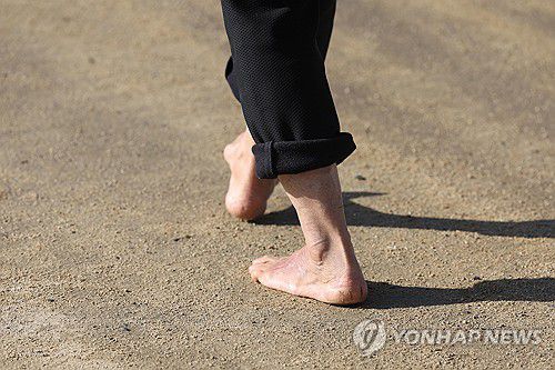 '봄볕 닮은 겨울'(대구=연합뉴스) 김현태 기자 = 16일 오후 대구의 낮 기온이 13도를 웃돈 가운데 수성못에서 한 시민이 맨발로 산책하고 있다. 2026.1.16 mtkht@yna.co.kr