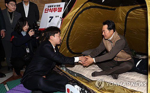 악수 나누는 장동혁-이준석(서울=연합뉴스) 배재만 기자 = 통일교·공천헌금 '쌍특검' 수용을 요구하며 단식 7일 차를 맞은 국민의힘 장동혁 대표가 21일 국회 로텐더홀 단식 농성장을 찾은 개혁신당 이준석 대표와 악수하고 있다. 2026.1.21 [공동취재] scoop@yna.co.kr