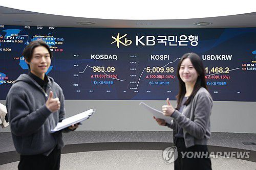 코스피, '꿈의 지수' 5000선 돌파(서울=연합뉴스) 코스피가 장중 5,000을 넘어선 가운데 22일 오전 서울 여의도 KB국민은행 딜링룸에서 딜러들이 미소를 짓고 있다. 2026.1.22 [KB국민은행 제공. 재판매 및 DB 금지] photo@yna.co.kr