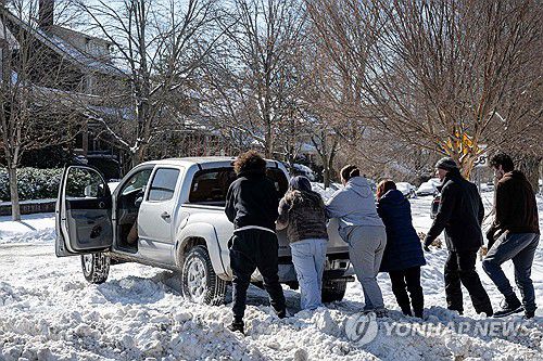 미 켄터키주 루이빌에서 폭설 속에 고립된 차량 치우는 주민들 [AFP=연합뉴스. 재판매 및 DB 금지]
