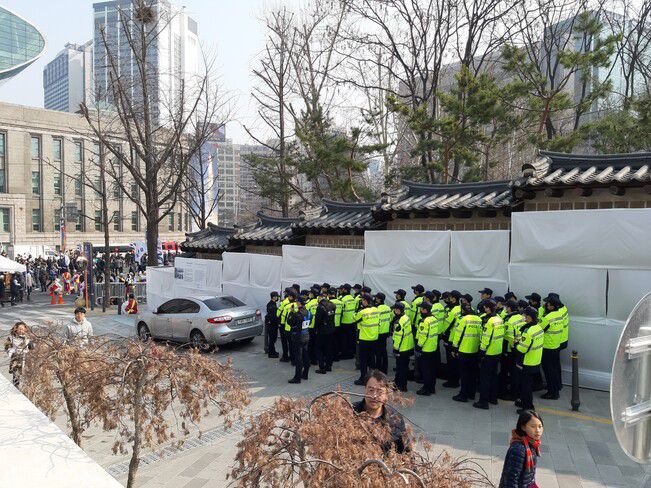 성공회대성당과 맞닿은 덕수궁 북쪽 담장의 흰천 설치물 앞에서 경계를 서고있는 전경들. 지난 1일 삼일절 100주년 기념대행진이 펼쳐진 오후의 모습이다.