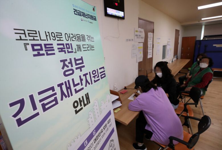 지난 5월 서울 송파구 삼전동 주민센터에서 시민들이 긴급재난지원금 신청서를 작성하고 있다. 연합뉴스