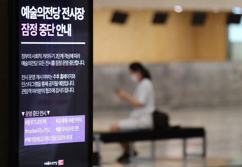 지난달 21일 서울 서초구 예술의전당 로비 전광판에 '사회적 거리 두기' 2단계 격상 조치에 따라 전시를 중단한다는 안내문이 나오고 있다. 연합뉴스