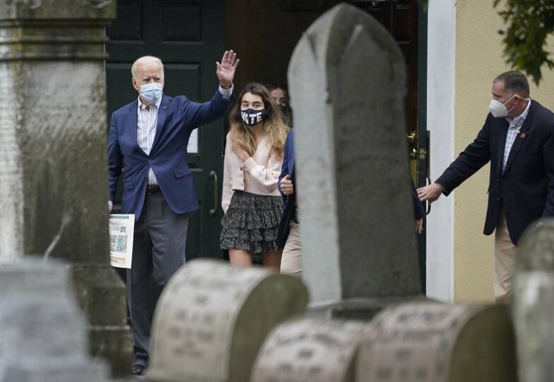 25일(현지시각) 미국 민주당 대선후보 조 바이든 전 부통령이 손녀와 함께 델라웨어주 윌밍턴 성당에서 열린 미사에 참석한 뒤 마스크를 쓴 채 시민들에게 손을 흔들고 있다. 윌밍턴/AFP 연합뉴스