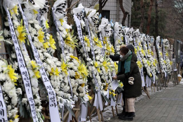 16개월 영아 정인이를 학대해 숨지게 한 혐의를 받고 있는 양부모의 첫 재판을 이틀 앞둔 11일 오전 서울 양천구 서울남부지검 정문 인근에서 대한아동학대방지협회 관계자들이 화환의 리본을 고정하고 있다. 김혜윤 기자 unique@hani.co.kr
