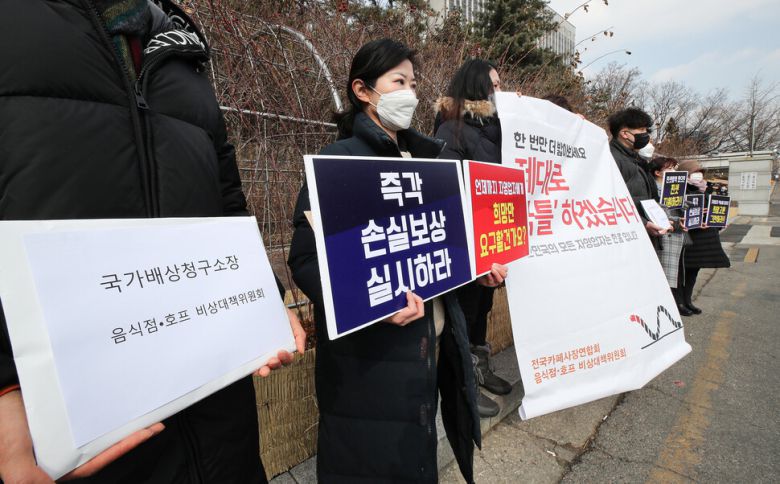 지난 19일 오후 서울 서초구 서울중앙지방법원 앞에서 열린 전국카페사장연합회·음식점 호프 비상대책위원회 2차 집단소송 기자회견에서 참석자들이 정부의 코로나19 사회적 거리두기 방침에 따른 영업 제한 즉각 손실보상을 촉구하는 성명서를 낭독하고 있다. 연합뉴스