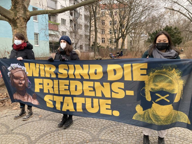 6일 독일 베를린 미테구에 있는 ‘평화의 소녀상’ 앞에서 열린 세계 여성의 날 기념집회에서 시민들이 ‘우리가 평화의 소녀상이다’라고 쓴 펼침막을 들고 서 있다.