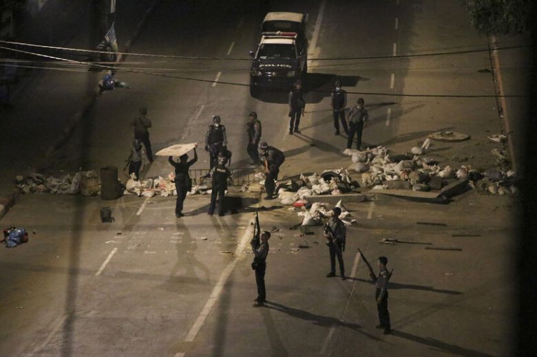 무장 경찰이 21일 미얀마 양곤에서 시위대가 설치해 놓은 바리케이드를 치우고 있다. 양곤/AP 연합뉴스