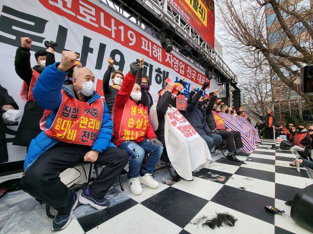 25일 오후 서울 여의도 국민은행 앞에서 자영업자들이 삭발을 마치고 구호를 외치고 있다. 고병찬 기자