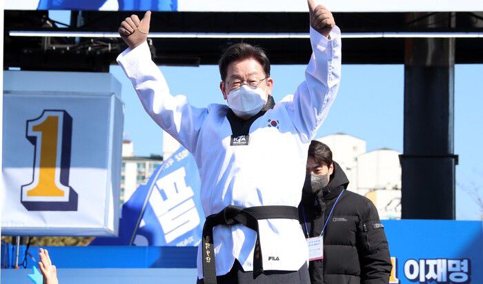 이재명 더불어민주당 대선후보가 20일 경기도 수원시 만석공원에서 열린 '검증된 실력과 성과, 대한민국을 위해 일하겠습니다!' 수원 유세에서 박상현 전 태권도 선수로부터 받은 '공약 9단' 도복을 입고 지지자에게 인사하고 있다. 공동취재사진