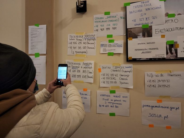 쉼터에서 머물고 있는 한 여성이 필요한 정보가 적혀있는 안내문을 스마트폰 카메라로 찍고 있다. 프셰미실/김혜윤 기자