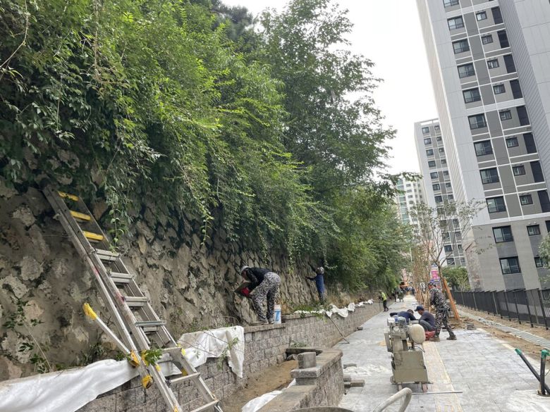 성남제일초등학교 주변을 감싸고 있는 석축에 대해 학부모들이 붕괴 위험을 제기하자, 인근 아파트 공사 현장에서 동원된 노동자들이 보수공사를 진행하고 있다.