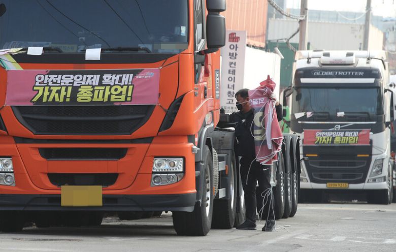 화물연대가 파업을 종료하고 현장 복귀를 결정한 지난해 12월9일 오후 경기도 의왕시 내륙컨테이너기지(ICD) 인근에 주차되어 있던 화물차에 붙어 있던 현수막을 한 화물연대 관계자가 떼어내고 있다. 신소영 기자 viator@hani.co.kr