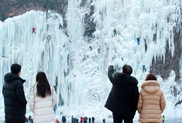 연일 지속된 최강 한파가 다소 누그러진 27일 강원 원주시 지정면 판대아이스파크 빙벽장을 찾은 일반 방문객이 거대한 빙벽을 오르는 동호인들의 모습을 지켜보며 감탄하고 있다. 연합뉴스