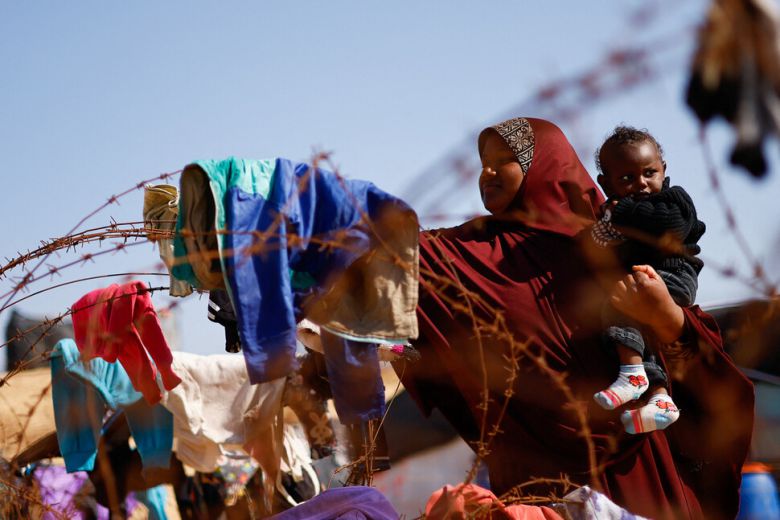 7일 가자지구 남부 라파흐에서 한 여성이 아이를 안고 철조망에 널어놓은 빨래를 살펴보고 있다. 로이터 연합뉴스