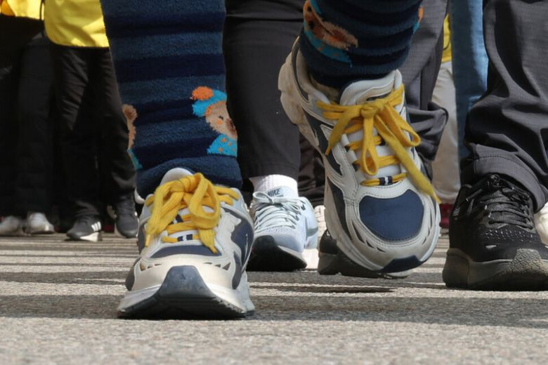 지난달 15일 경기도 안산시에서 열린 ‘세월호 참사 10주기 전국시민행진’에 참석한 권순범 학생 엄마 최지영씨가 노란색 끈을 묶은 운동화를 신고 단원고등학교에서 안산시청 방향으로 걷고 있다. 김혜윤 기자
