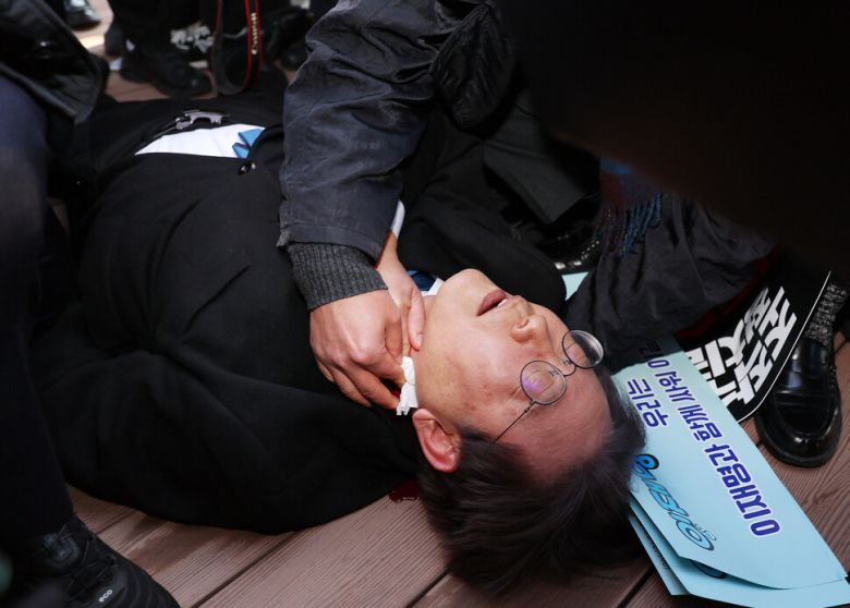 더불어민주당 이재명 대표가 2일 오전 부산 강서구 가덕신공항 부지를 둘러본 뒤 왼쪽 목 부위 피습을 당해 바닥에 누워 병원 호송을 기다리고 있다. 연합뉴스