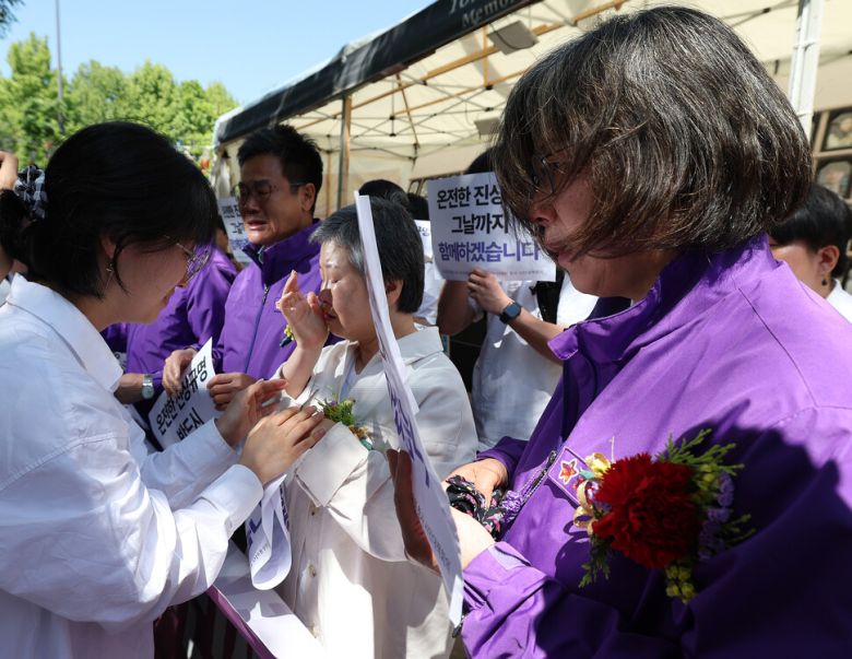 어버이날인 8일 오전 서울광장 이태원참사 분향소에서 유족들이 청년들이 달아준 카네이션을 하고 눈물을 흘리고 있다. 연합뉴스