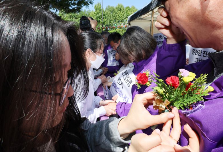 청년들이 유가족들에게 카네이션을 달아주고 있다. 신소영 기자