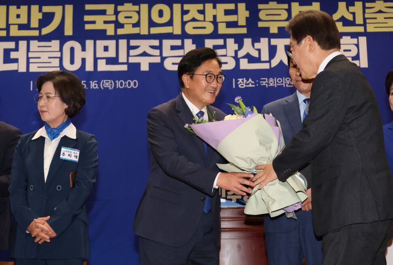 더불어민주당 국회의장 후보로 선출된 우원식 의원이 16일 오전 국회 의원회관에서 열린 제22대 전반기 국회의장단 후보 선출을 위한 당선자 총회에서 이재명 대표로부터 꽃다발을 받고 있다. 연합뉴스