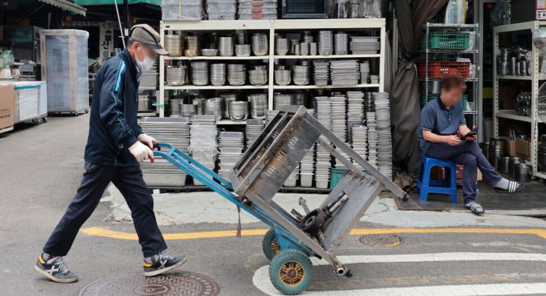 지난달 20일 서울 중구 황학동 주방거리에서 한 상인이 중고 주방기구를 옮기고 있다. 연합뉴스